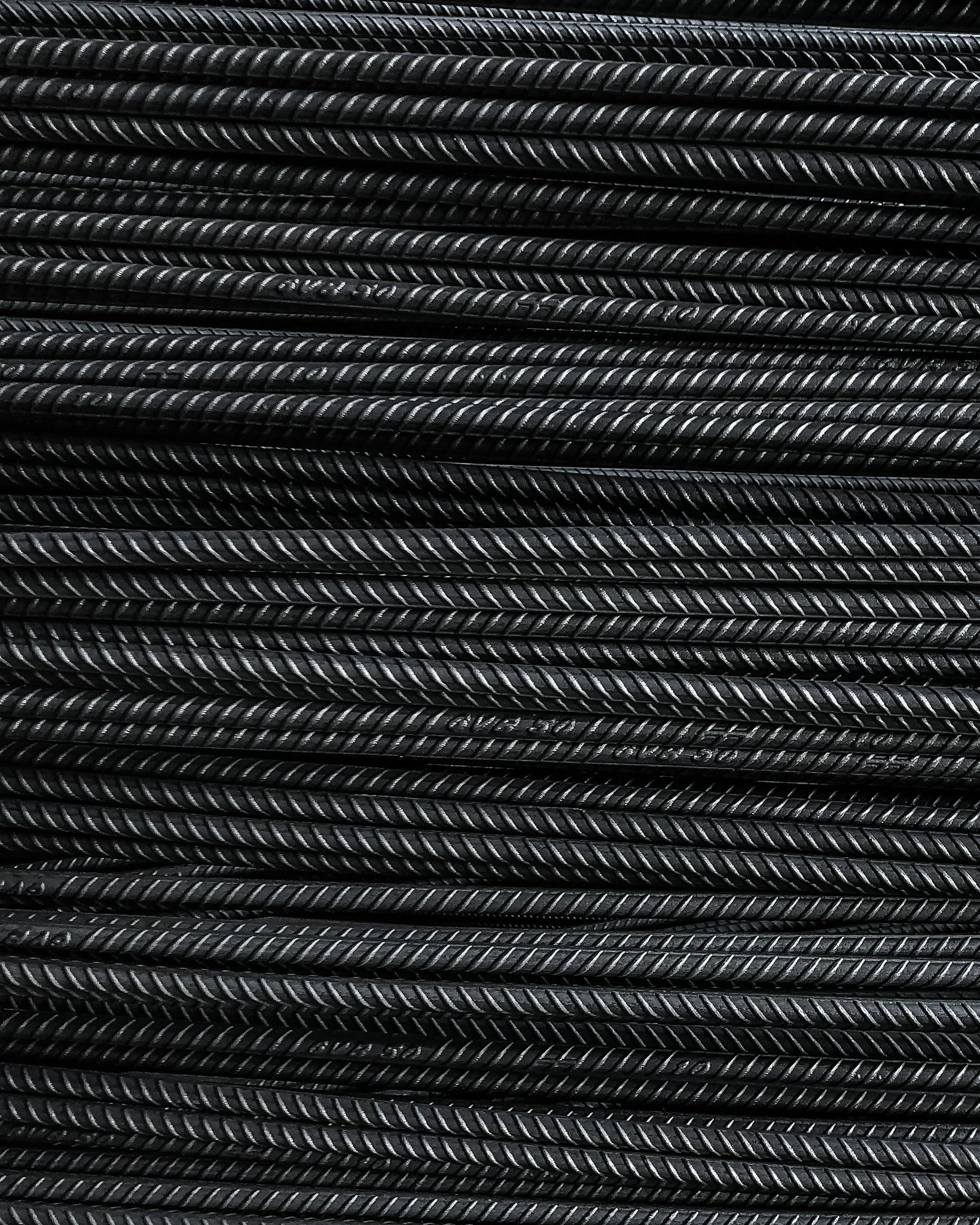 Close-up view of neatly stacked metal rebars showcasing detailed texture and industrial feel.